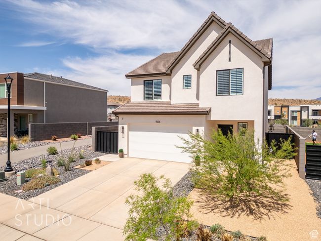 View of front of home with stucco siding, fence, a tile roof, concrete driveway, and an attached garage | Image 44