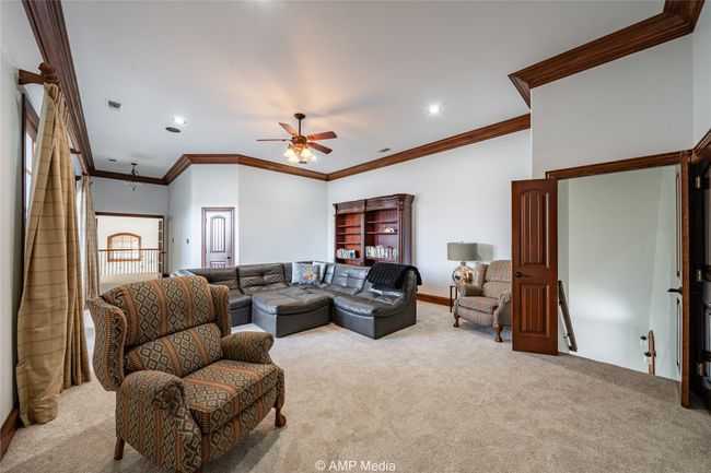 Carpeted living room with ceiling fan and ornamental molding | Image 27