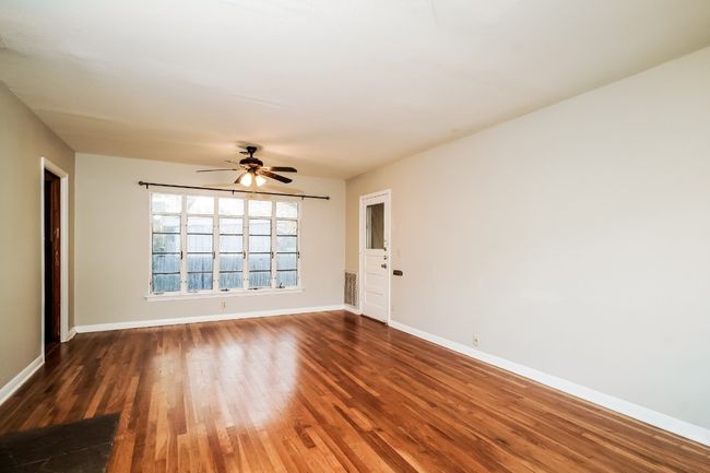 Empty room with wood finished floors and a ceiling fan | Image 5