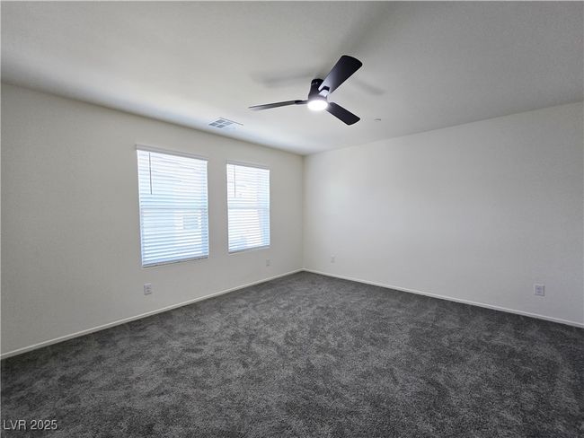 Empty room featuring ceiling fan, dark colored carpet, and baseboards | Image 28