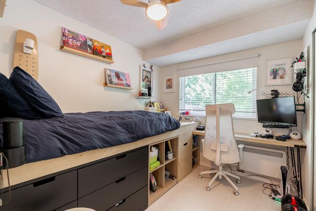 Bedroom featuring a textured ceiling, an office area, and a ceiling fan | Image 19