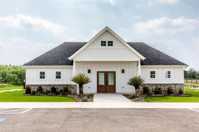 View of Community Center front facade featuring a front lawn and french doors | Image 1