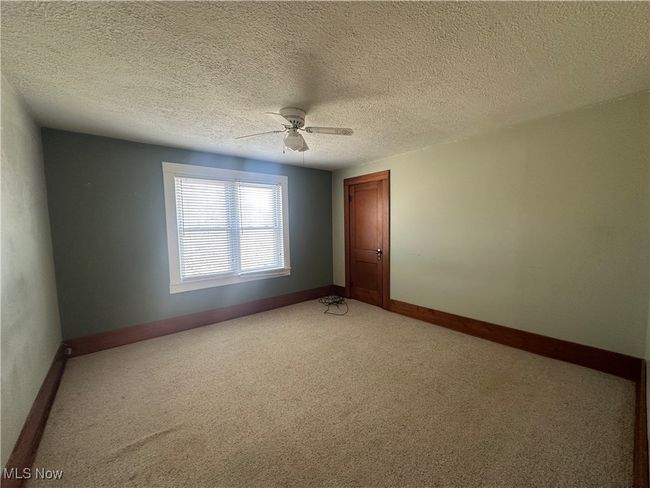 Empty room featuring a ceiling fan, baseboards, and light colored carpet | Image 13