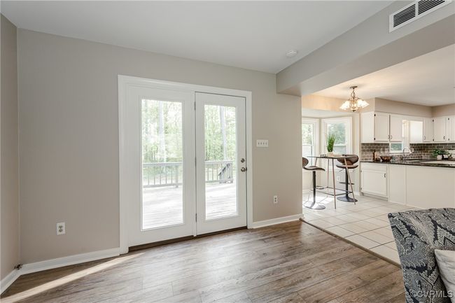Doorway to outside featuring a sink, a chandelier, light wood finished floors, baseboards, and visible vents | Image 28