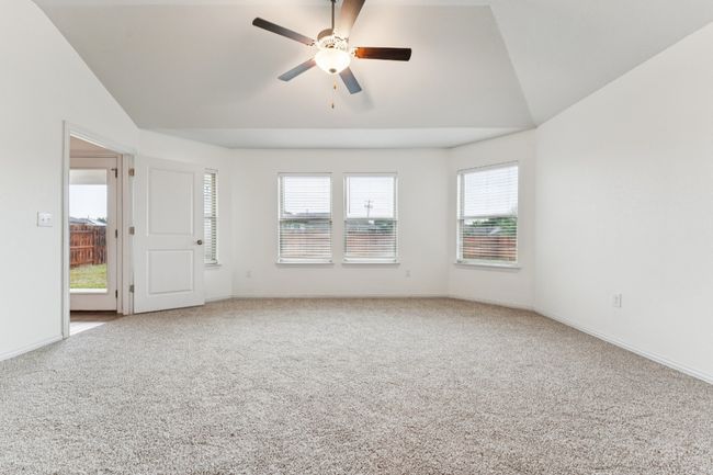 Carpeted empty room featuring vaulted ceiling and a ceiling fan | Image 8