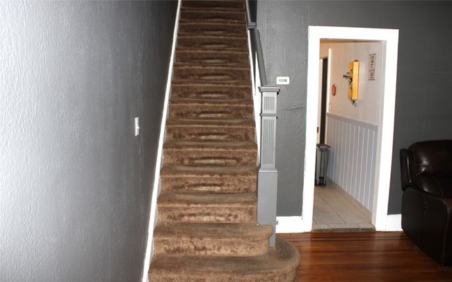 Staircase featuring a textured wall and wood finished floors | Image 10