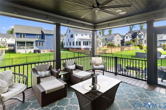 Wooden deck featuring a residential view, an outdoor living space, and ceiling fan | Image 40