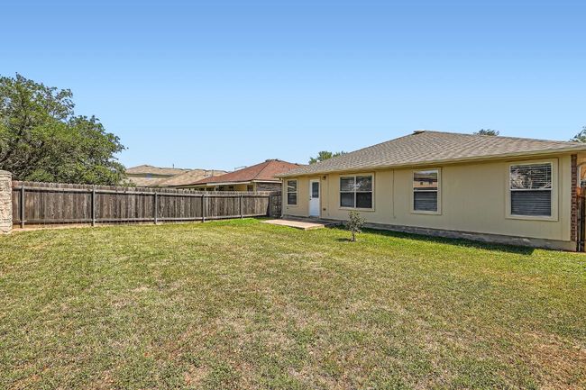 Back of house featuring a lawn, a patio, roof with shingles, and a fenced backyard | Image 24
