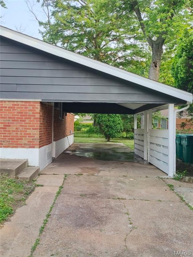 View of parking / parking lot featuring driveway and a carport | Image 16