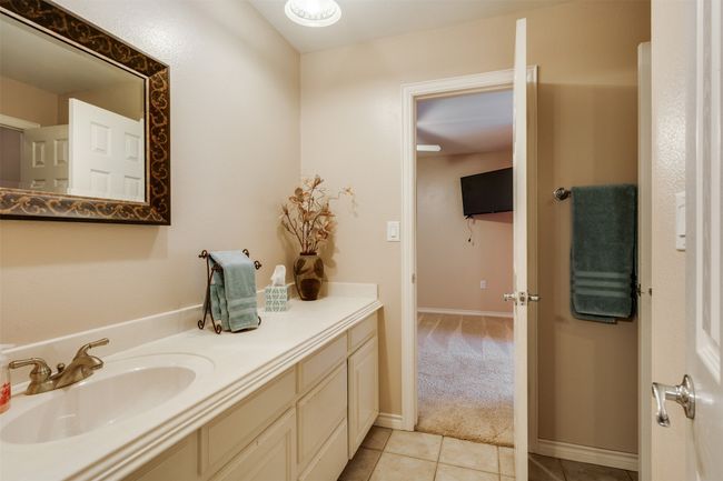 Bathroom featuring baseboards, tile patterned floors, and vanity | Image 15