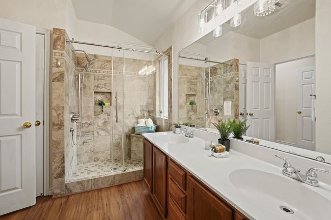 Updated walk-in shower with sleek tile and glass door adds a modern touch. 9349 Bernoulli Dr., Austin, TX 78748 | Image 17