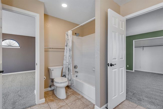 Bathroom featuring tile patterned flooring, shower / bath combo with shower curtain, baseboards, and toilet | Image 24