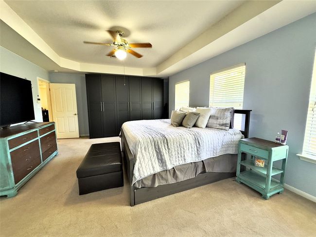 Master Bedroom with light colored carpet, a tray ceiling, and multiple windows | Image 29