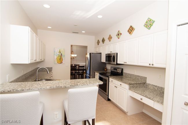 Kitchen features stainless steel appliances and recessed lighting. | Image 10