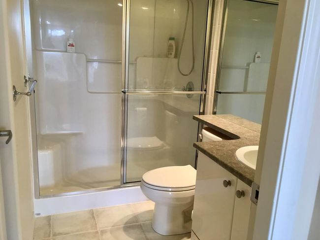 Full bath with toilet, a stall shower, tile patterned floors, and vanity | Image 11