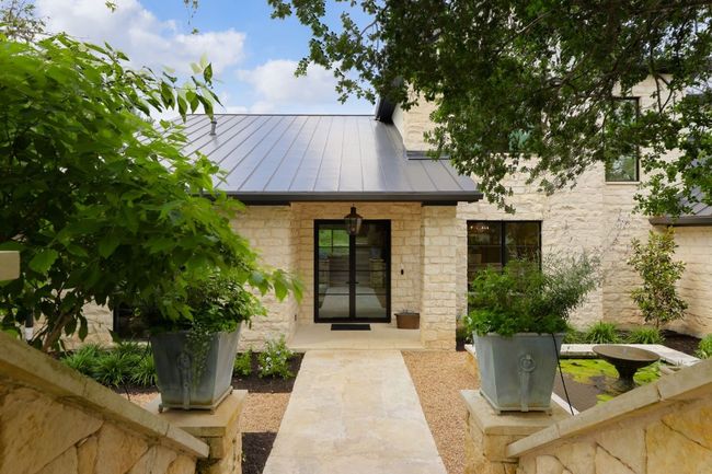 View of exterior entry with a standing seam roof, a metal roof, and stone siding | Image 40