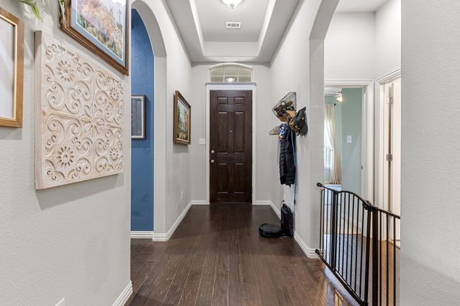 Hall featuring arched walkways, baseboards, visible vents, and hardwood / wood-style flooring | Image 9