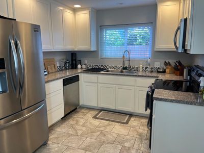 Updated kitchen complete with granite counter tops, a custom backsplash and new appliance stove, dishwasher, and microwave. | Image 2