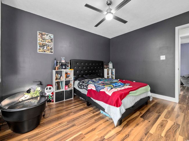 Bedroom with a ceiling fan, baseboards, and wood finished floors | Image 21