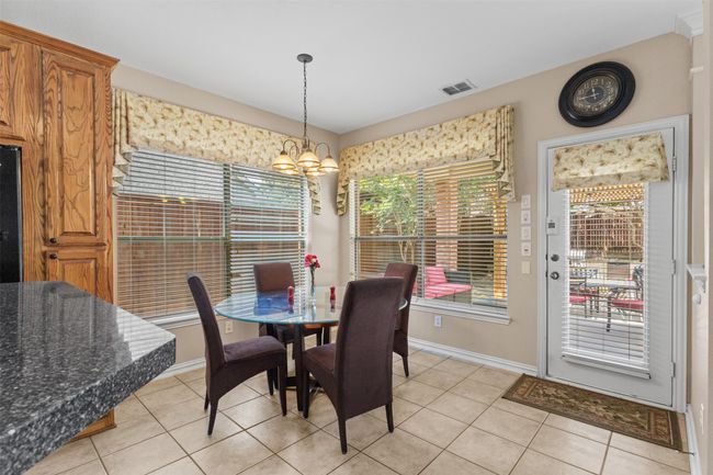 Dining room with a chandelier, light tile patterned floors, and baseboards | Image 11