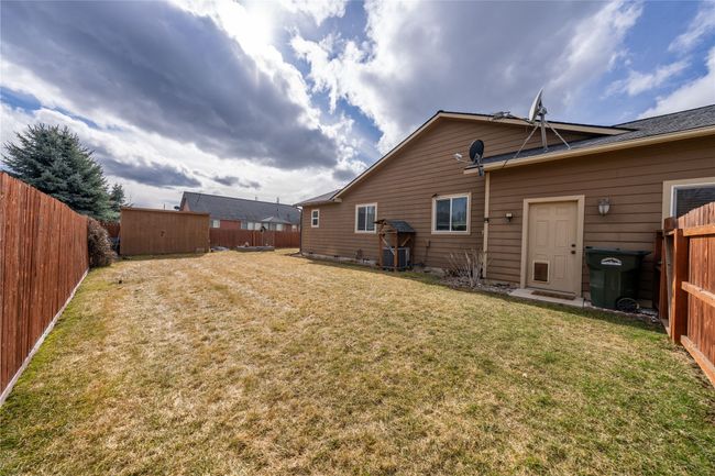 Rear view of property featuring a storage shed, an outdoor structure, a yard, and a fenced backyard | Image 24