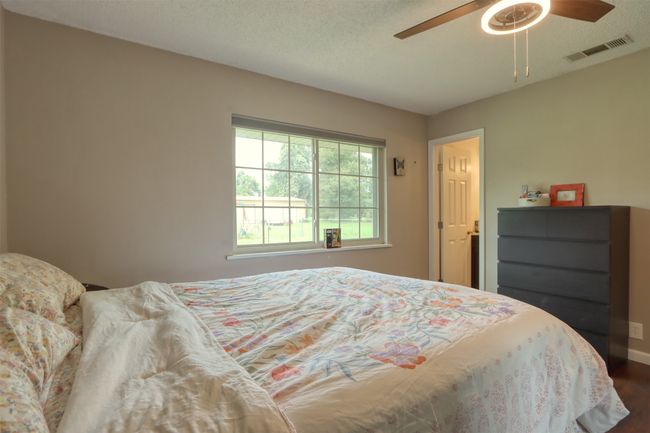 Bedroom featuring dark wood finished floors, a textured ceiling, and a ceiling fan | Image 36