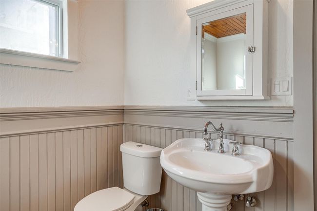 Half bath featuring wainscoting, toilet, and a sink | Image 29