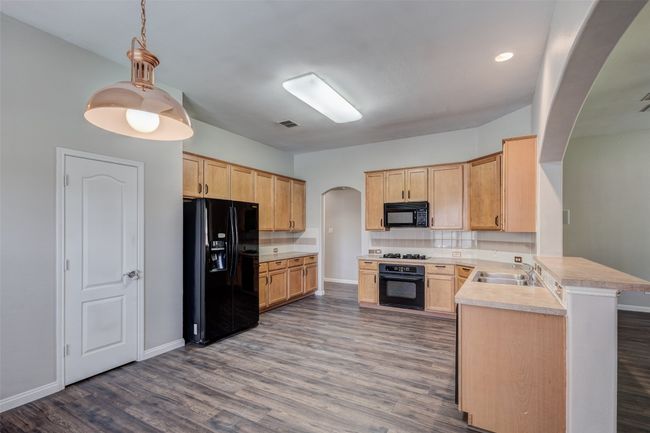 Unfurnished room with lofted ceiling, dark wood-type flooring, baseboards, and ceiling fan | Image 12
