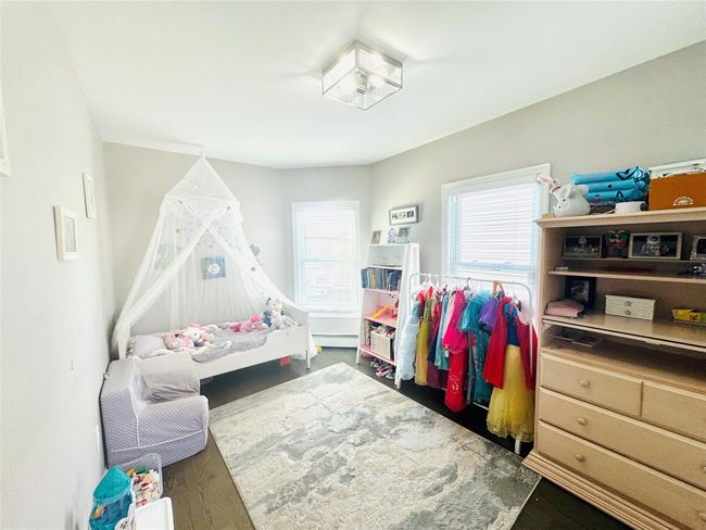 Bedroom featuring baseboard heating and wood finished floors | Image 12