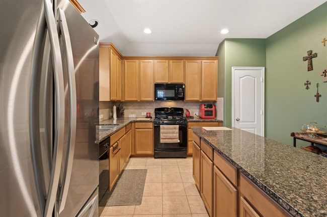 The kitchen features wood cabinets, creating a clean and timelessaesthetic. | Image 12