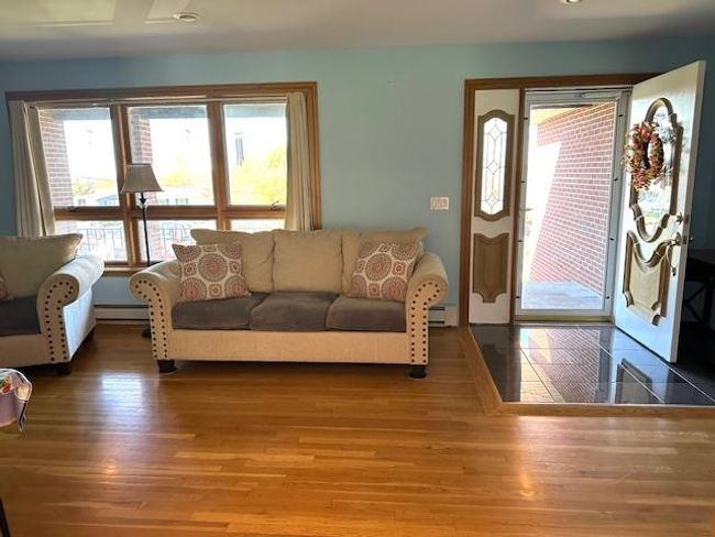 Living room with baseboard heating and hardwood / wood-style flooring | Image 8