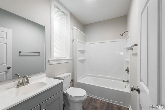 Full bathroom with vanity, wood finished floors, and shower / bath combination | Image 16