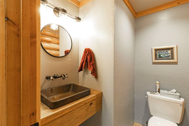 Half bath featuring toilet, vanity, and a textured wall | Image 14