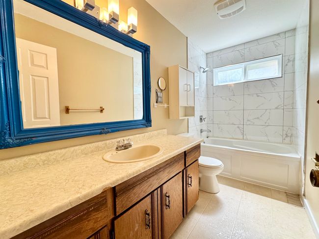 Bathroom with vanity, washtub / shower combination, and tile patterned flooring | Image 13