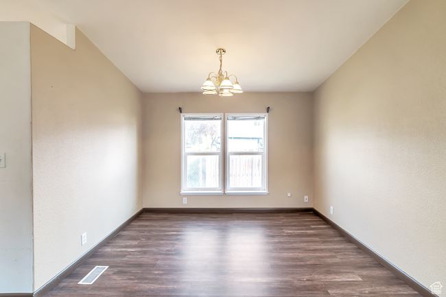 Spare room with a chandelier, wood finished floors, and baseboards | Image 10