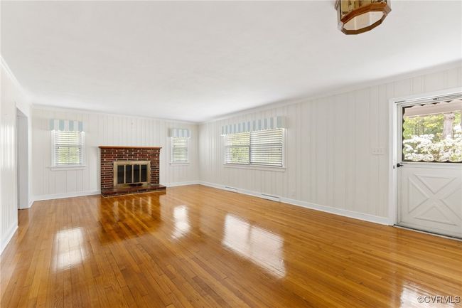 Unfurnished living room featuring visible vents, baseboards, light wood-style flooring, and a healthy amount of sunlight | Image 7