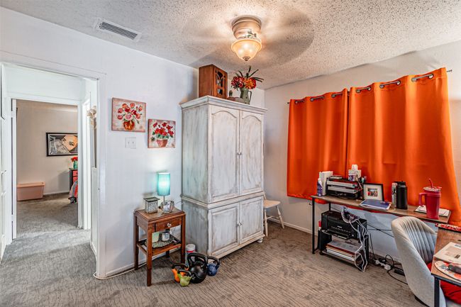 Carpeted office space featuring a textured ceiling | Image 17