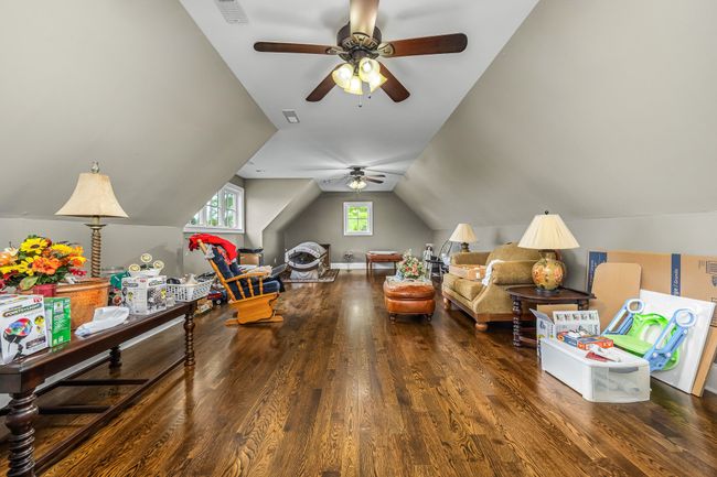 A large recreation room with hardwood flooring and a full bath offers a versatile space perfect for a variety of activities and gatherings. | Image 62