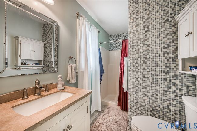 Bathroom featuring vanity, a stall shower, light tile patterned floors, and tile walls | Image 19