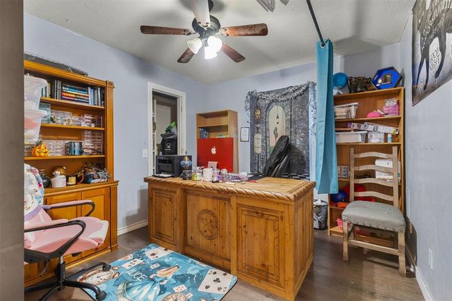 Home office with dark wood-type flooring and ceiling fan | Image 10