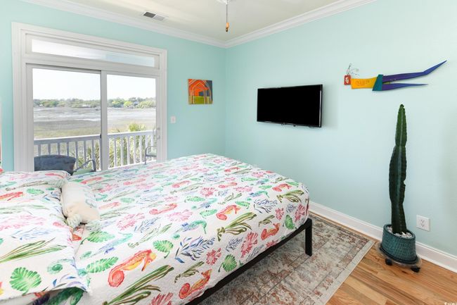 Bedroom featuring wood finished floors, visible vents, baseboards, access to outside, and crown molding | Image 15