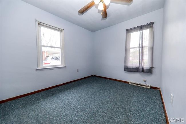 Carpeted empty room featuring baseboards, a wealth of natural light, and a ceiling fan | Image 10