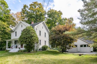 View of side of home with a garage, a porch, and a lawn | Image 3