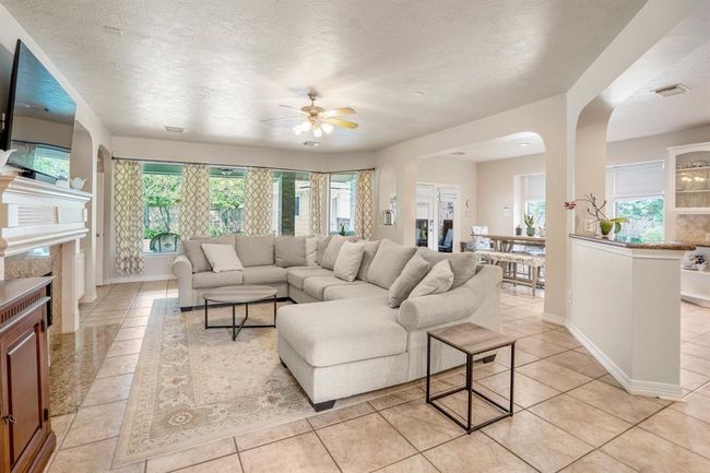 A wall of windows with views of the gorgeous backyard just beyond the living room area are a focal point of the room. | Image 11