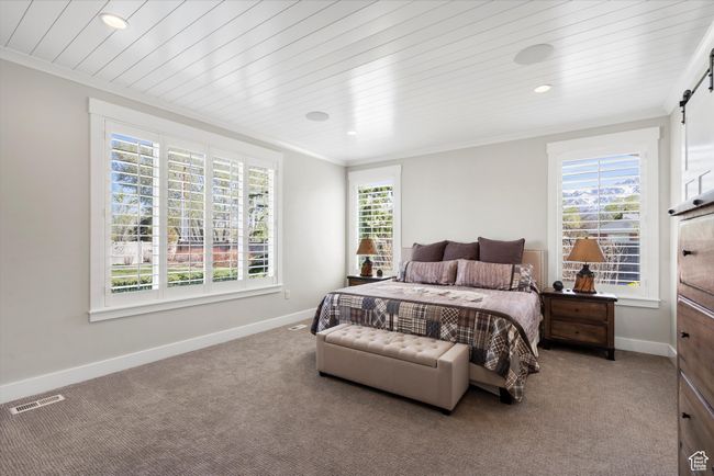 Bedroom featuring ornamental molding, baseboards, and a barn door | Image 23