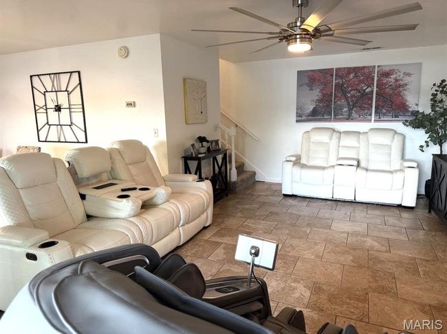 Living area featuring a ceiling fan, stairway, and stone finish floors | Image 22