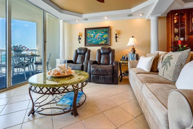 Living room with ornamental molding, a raised ceiling, light tile patterned flooring, and ornate columns | Image 10