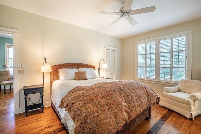 Bedroom with hardwood / wood-style flooring and ceiling fan | Image 28