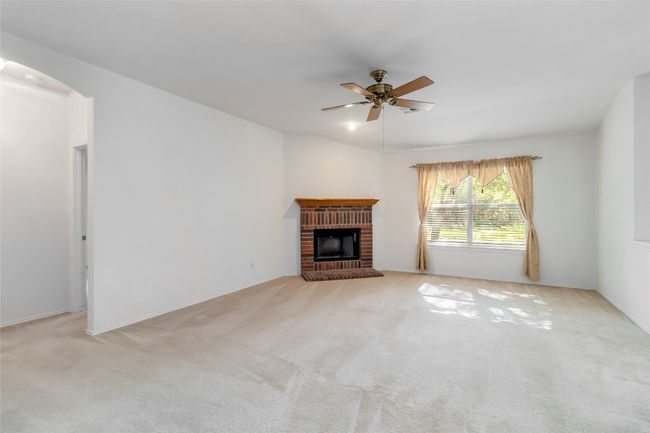 Unfurnished living room with a ceiling fan, a fireplace, and carpet | Image 12