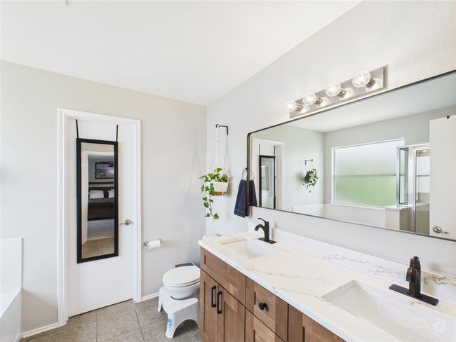 Full bath featuring double vanity, tile patterned floors, and an enclosed shower | Image 14